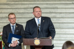 Sen. Martin standing in front of a podium with another man in the background