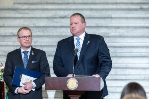 Sen. Martin standing in front of a podium with another man in the background